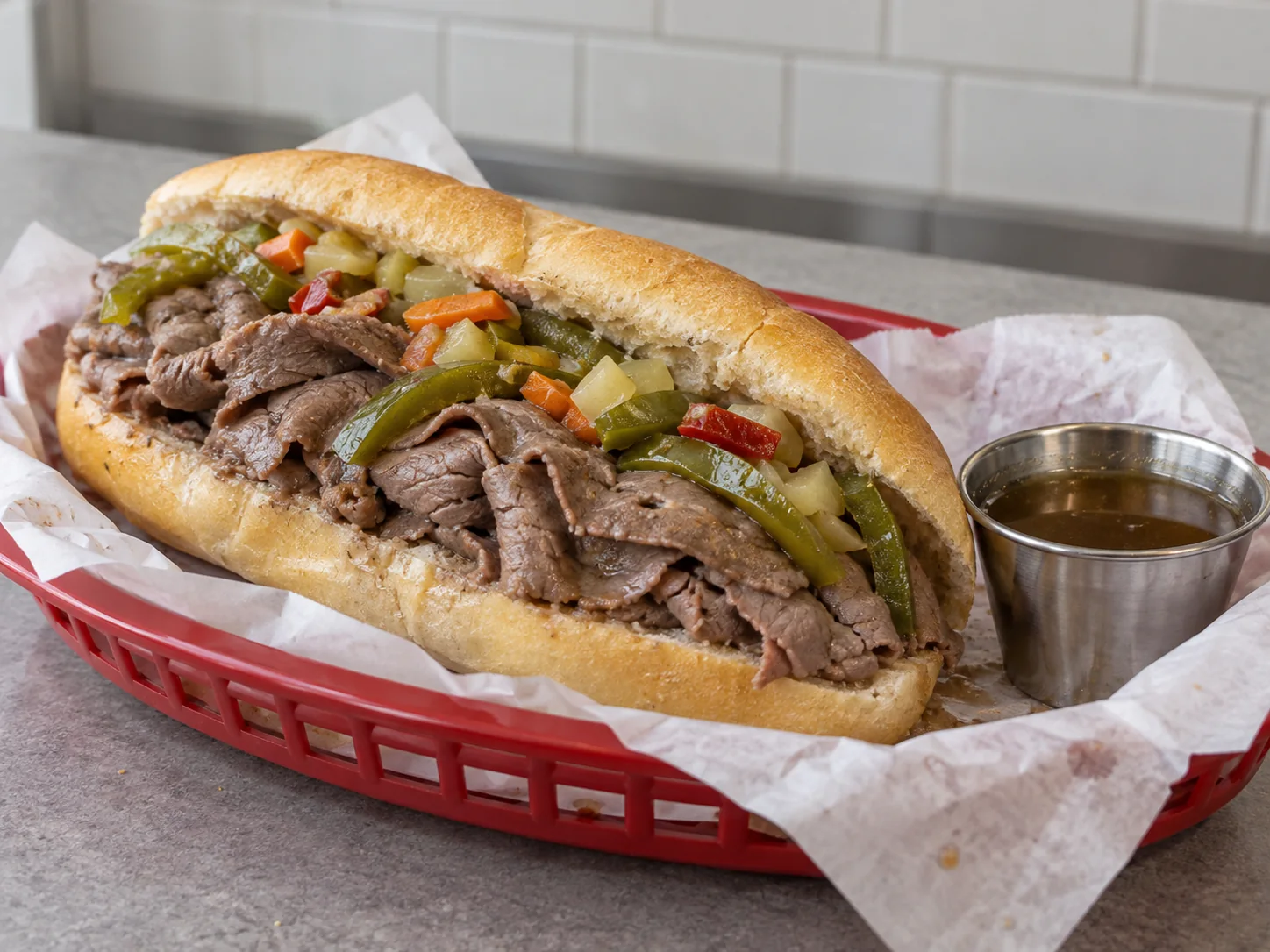 Imagen digital ilustrativa de un Italian beef con ternera en láminas finas, pimiento verde y encurtidos.